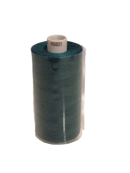 Spool of green thread on a white background