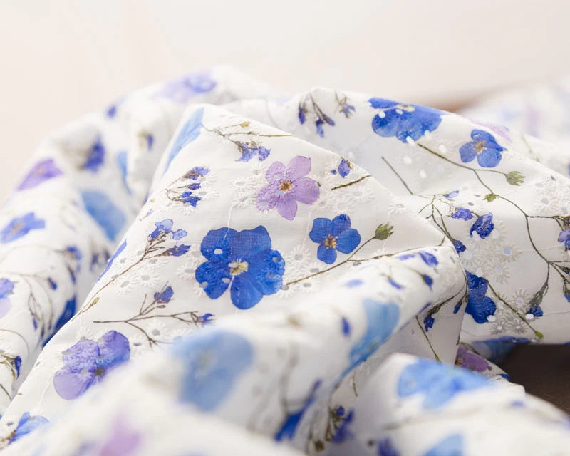 Close-up of floral fabric with blue flowers on a white background