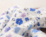 Close-up of floral fabric with blue flowers on a white background